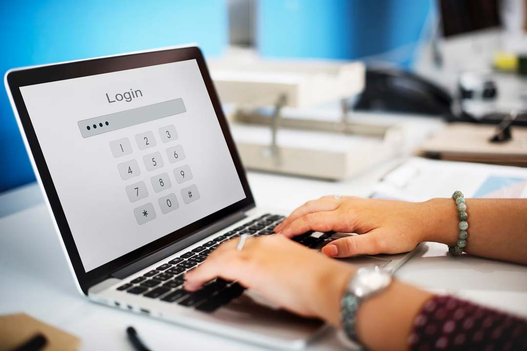 Mãos de mulher digitando em um notebook uma senha para fazer login em algum site