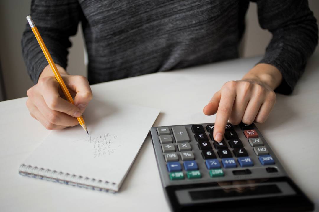 bloco-de-notas-pessoa-e-calculadora