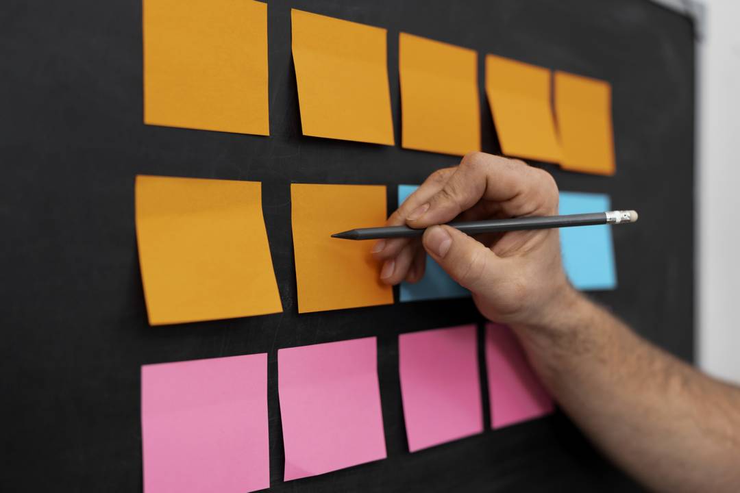 vista-lateral-escrevendo-a-mao-em-laranja-post-it