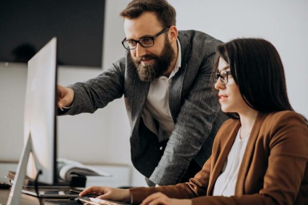 dois parceiros de negócios trabalhando juntos no computador do escritório