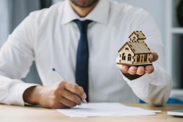 escrevendo-agente-imobiliario-segurando-casa