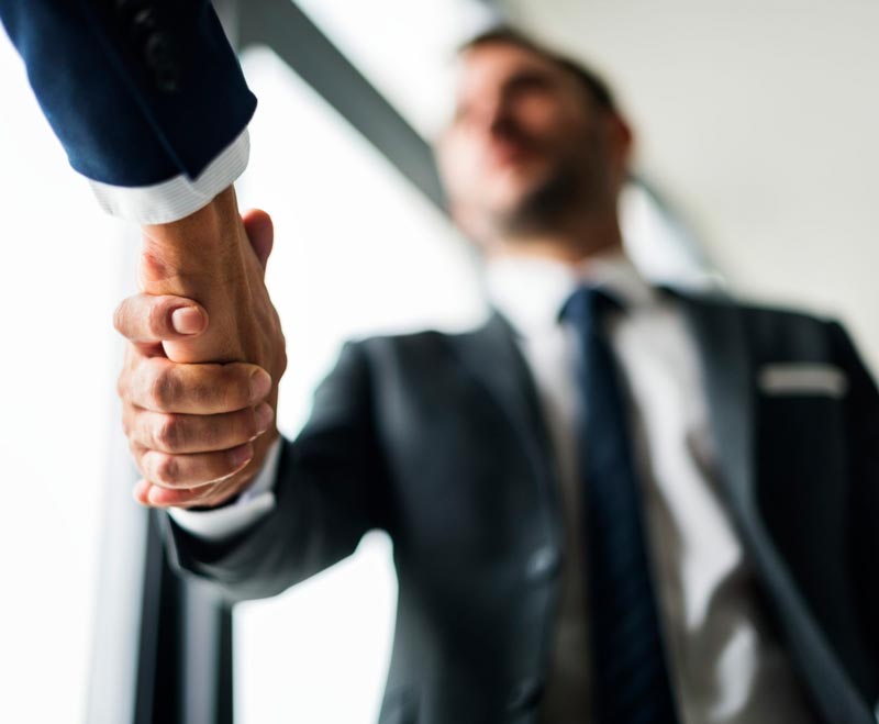 Executivos apertando as mãos como forma de cumprimento.