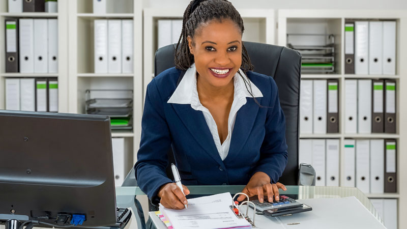 Mulher jovem, negra, profissional de contabilidade trabalhando no escritório.
