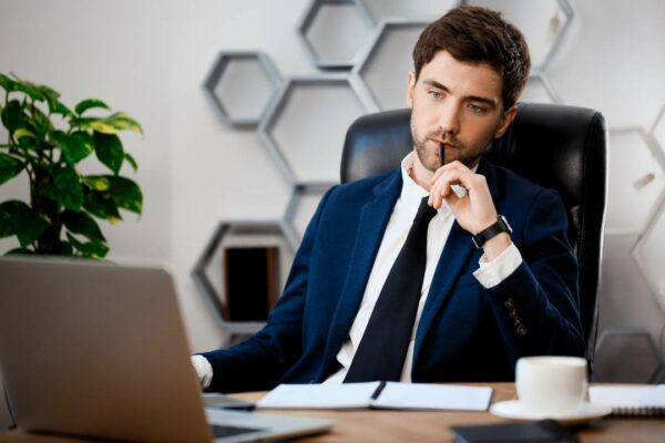 jovem-empresário-de-sucesso-sentado-local de trabalho-escritório-fundo