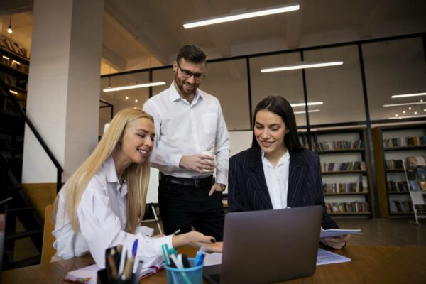 homem-e-duas-mulheres-em-empresa-olhando-notbook